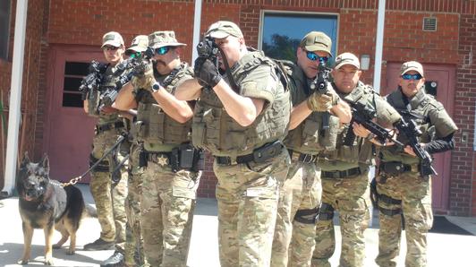 SWAT Officers with weapons and dog