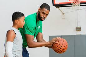 man coaching child on basketball